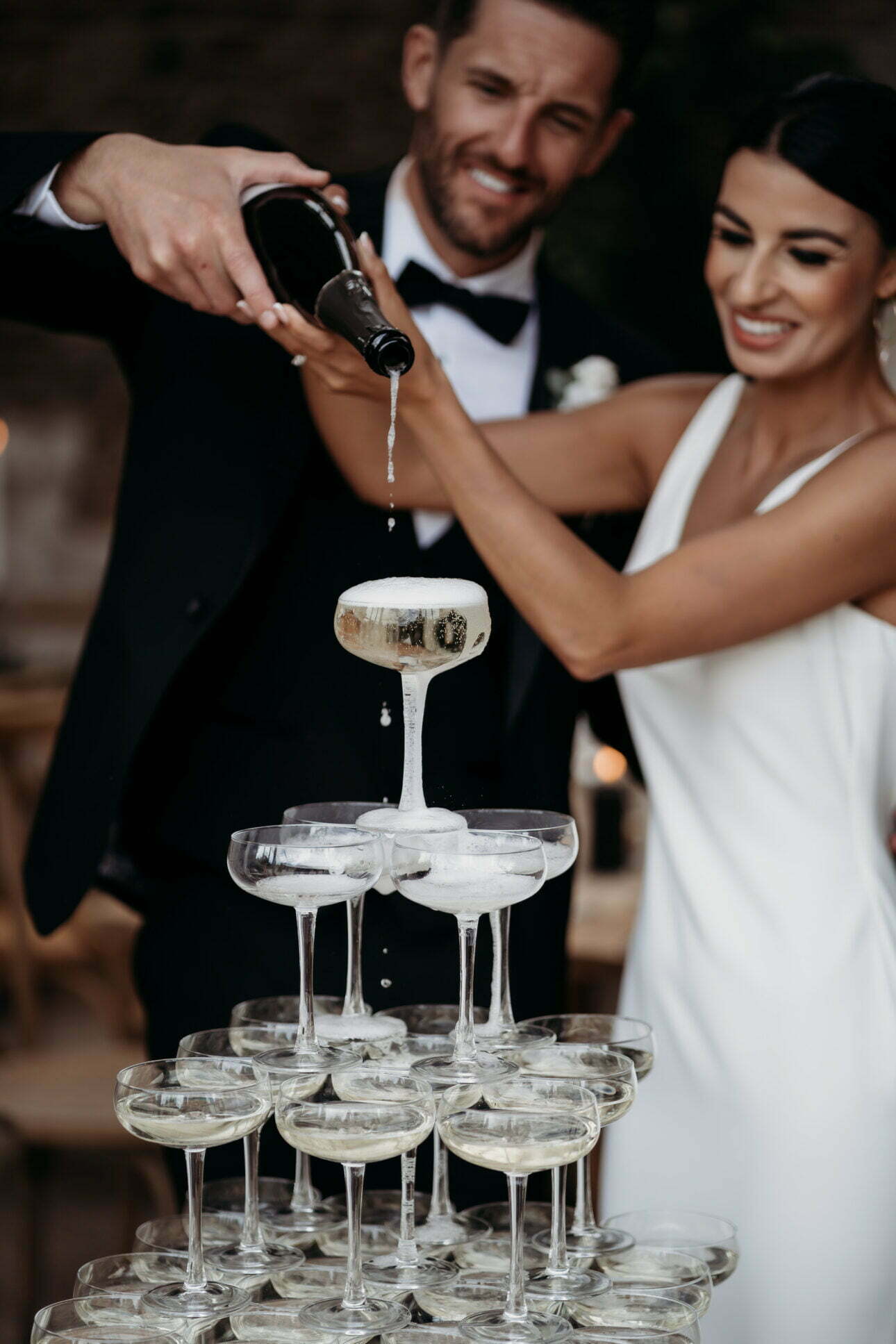 A top tip for a perfect champagne tower wedding photograph is to stay close together and snuggle up